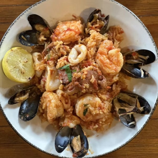 Havana 151's seafood paella with mussels, shrimp, and calamari, garnished with a lemon wedge.