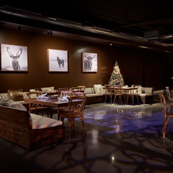 The Loft at Lena's dining area with dark walls, wooden tables, benches, and animal portraits.