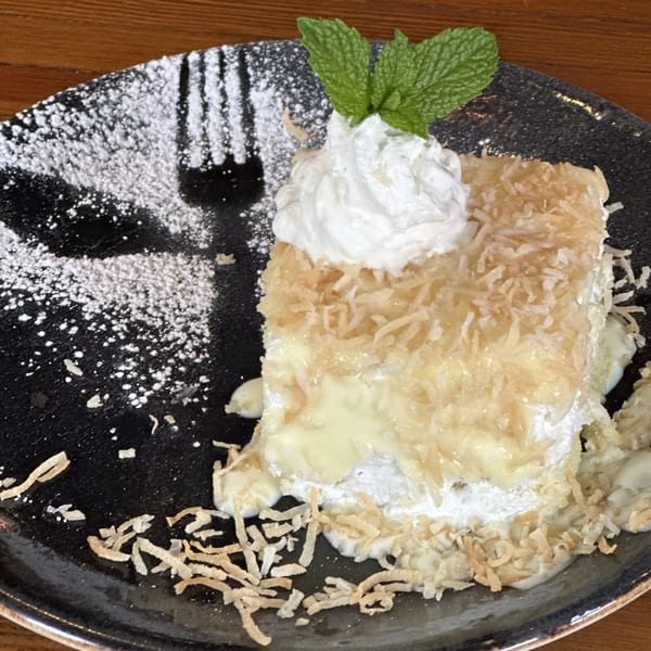 A slice of Havana 151's coconut tres leches cake, topped with whipped cream and mint.