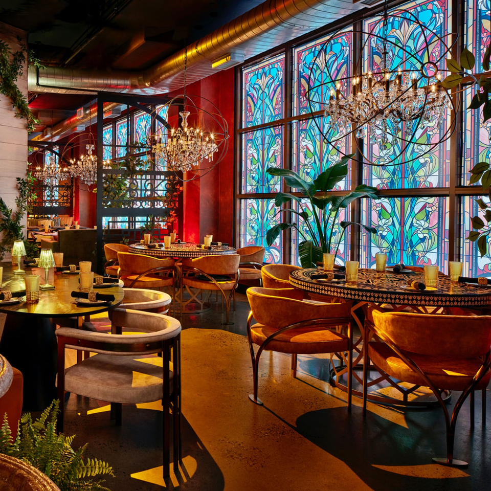 Havana 151 restaurant interior with ornate chandeliers, stained-glass windows, and velvet chairs.