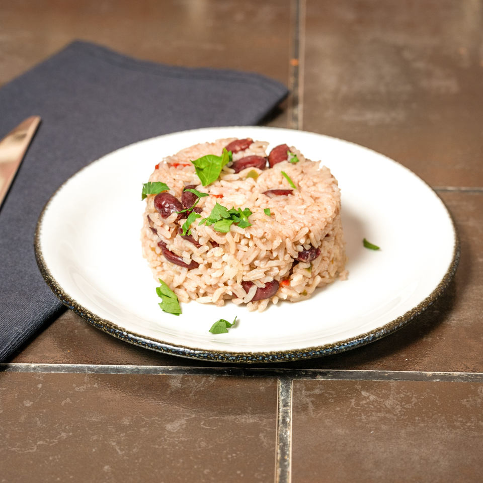 A serving of Havana 151's Cuban rice and beans, garnished with fresh parsley on a white plate.